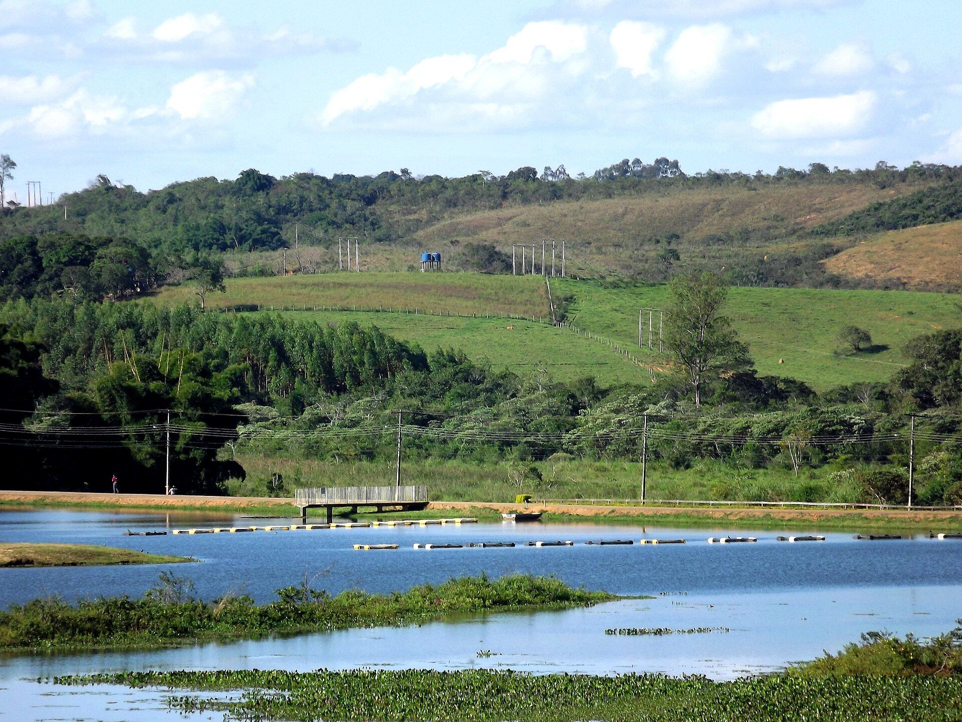 Lago com linhas de tanques-rede para criação de tilápia entre colinas verdes